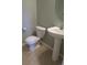 A clean bathroom features a toilet and pedestal sink with neutral-toned tile flooring at 559 Alton Way # E, Denver, CO 80230