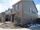Rear view of a charming townhouse with a brick facade, private patio, and a convenient outdoor grilling area at 559 Alton Way # E, Denver, CO 80230