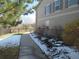 Well maintained side yard with a sidewalk leading toward a black metal fence and flowering bushes at 559 Alton Way # E, Denver, CO 80230