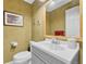 Cozy bathroom with framed art, a toilet, a sink, and a large mirror in a home at 5964 S Florence Ct, Englewood, CO 80111