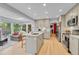 Bright kitchen with an island, bar seating, hardwood floors, modern appliances, and an adjacent living area at 5964 S Florence Ct, Englewood, CO 80111