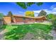 Green backyard with brick house is an expansive space ideal for outdoor activities at 2311 Emery Pl, Longmont, CO 80501