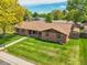 Well-maintained brick house with a large front yard and mature trees at 2311 Emery Pl, Longmont, CO 80501