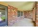 Cozy, covered front porch with brick columns, a home address number, and outdoor light fixture at 2311 Emery Pl, Longmont, CO 80501