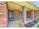 Inviting covered front porch with brick columns, a front door, and space for decorative plants and seating at 2311 Emery Pl, Longmont, CO 80501