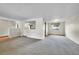 Open living space with neutral carpet, white walls, and a view into other rooms with hardwood floors at 2311 Emery Pl, Longmont, CO 80501