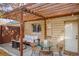 A cozy backyard patio with a wooden pergola, string lights, a fire pit, and outdoor furniture at 3929 Shoshone St, Denver, CO 80211