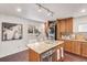 Functional kitchen featuring wood cabinets, granite island, and modern stainless steel appliances at 3929 Shoshone St, Denver, CO 80211