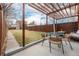 Charming backyard showcasing a pergola-covered patio with a dining table, fire pit, and a spacious grassy area at 3929 Shoshone St, Denver, CO 80211