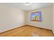 Simple bedroom with hardwood floors and large window at 1749 Foster Dr, Longmont, CO 80501