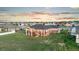 Stunning exterior elevation of house featuring tiered decks and a spacious backyard with a sunset sky at 29303 E 165Th Ave, Brighton, CO 80603