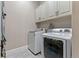 Modern laundry room with white washer and dryer, upper cabinets, and neutral paint at 29303 E 165Th Ave, Brighton, CO 80603