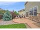 Backyard patio with seating area and stone accents on the home's exterior at 6461 S Ider St, Aurora, CO 80016