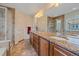 Bathroom featuring tile floors, dual sinks, and a glass-enclosed shower at 6461 S Ider St, Aurora, CO 80016