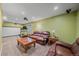 Finished basement living room with brown leather couches, projector, and movie screen at 6461 S Ider St, Aurora, CO 80016