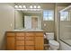 Bathroom featuring double sinks, wood cabinetry, and a shower with glass doors at 14675 Golden Eagle Run, Broomfield, CO 80023