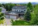 Beautiful two-story home with a stone accent garage, manicured lawn, and mature trees at 14675 Golden Eagle Run, Broomfield, CO 80023
