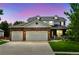 Beautiful two-story home with a stone accent garage, manicured lawn during twilight at 14675 Golden Eagle Run, Broomfield, CO 80023