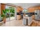 Bright kitchen with stainless steel appliances, wood cabinets and sliding glass door leading to back yard at 14675 Golden Eagle Run, Broomfield, CO 80023