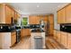Kitchen boasts stainless steel appliances, wood cabinets, black countertops and breakfast bar at 14675 Golden Eagle Run, Broomfield, CO 80023