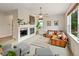 Comfortable living room with fireplace, large window, and stylish leather sofa at 14675 Golden Eagle Run, Broomfield, CO 80023