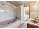 Well-lit bathroom showcasing a soaking tub with tiled surround and double sinks at 21345 Cliffwoods Trl, Morrison, CO 80465