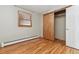 This bedroom features a hardwood floor, natural lighting, and a closet with sliding doors at 21345 Cliffwoods Trl, Morrison, CO 80465