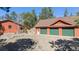 Detached garage with three green doors next to home with red roof surrounded by lush trees at 21345 Cliffwoods Trl, Morrison, CO 80465