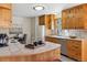 Bright kitchen featuring light wood cabinetry, tile backsplash, and a convenient breakfast bar area at 21345 Cliffwoods Trl, Morrison, CO 80465