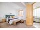 Bright bedroom with ensuite bath includes a decorative bed, bench, and a neutral color palette at 1070 Cypress Way, Castle Rock, CO 80108