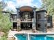 Stunning home exterior with a pool, balcony, stone accents, and manicured landscaping, offering luxurious outdoor living at 1070 Cypress Way, Castle Rock, CO 80108