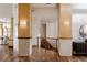 Bright hallway featuring hardwood floors and wood-trimmed pillars with decorative sconces at 1070 Cypress Way, Castle Rock, CO 80108