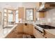 Kitchen featuring modern appliances, marble backsplash, lots of cabinet space, and a view of the wooded outdoors at 1070 Cypress Way, Castle Rock, CO 80108