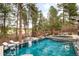 Beautiful pool with seating area and waterfall feature surrounded by lush trees at 1070 Cypress Way, Castle Rock, CO 80108
