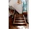 Modern staircase featuring wood steps, black metal railings, and a unique glass art piece at 1070 Cypress Way, Castle Rock, CO 80108