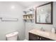 Bathroom with updated vanity, granite countertop, open shelves, and a framed mirror reflecting the glass enclosed shower at 742 Cameron Ln, Longmont, CO 80504