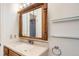 Bathroom with a framed mirror, glass shelving, and a vanity with a light-colored countertop at 2603 W 100Th Pl, Denver, CO 80260