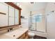 Bathroom with vanity, framed mirror, glass shelving, and a shower with glass enclosure at 2603 W 100Th Pl, Denver, CO 80260