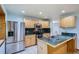 Well-lit kitchen featuring stainless steel appliances, wood cabinets, and tile flooring at 2603 W 100Th Pl, Denver, CO 80260
