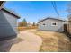 View of the backyard featuring a fenced yard, a detached garage, and mature trees at 5094 Meade St, Denver, CO 80221