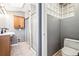 Bathroom with double sink vanity, oak cabinets, glass block window, and tiled shower at 5094 Meade St, Denver, CO 80221