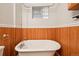 Classic clawfoot tub with unique glass block window and wood paneling in bathroom at 5094 Meade St, Denver, CO 80221