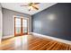 Bedroom with dark gray accent wall, hardwood floors, and French doors leading outside at 5094 Meade St, Denver, CO 80221