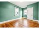 Cozy bedroom featuring hardwood floors, two windows for light and a closet door at 5094 Meade St, Denver, CO 80221