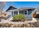 Inviting front porch showcasing the home's blue exterior and white trim with mature landscaping at 5094 Meade St, Denver, CO 80221