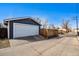 Detached garage with a wide door and spacious driveway for parking convenience at 5094 Meade St, Denver, CO 80221