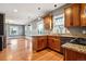 Open-concept kitchen with wood cabinets, granite countertops, and hardwood floors flowing into a spacious living area at 5094 Meade St, Denver, CO 80221