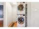 Bright laundry area with stacked washer and dryer, plus useful built in shelving for storage at 5094 Meade St, Denver, CO 80221