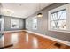 Bright living room showcasing multiple windows, wood floors and a modern lighting fixture at 5094 Meade St, Denver, CO 80221