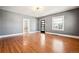 Bright living room showcasing hardwood floors, large windows and a modern lighting fixture at 5094 Meade St, Denver, CO 80221